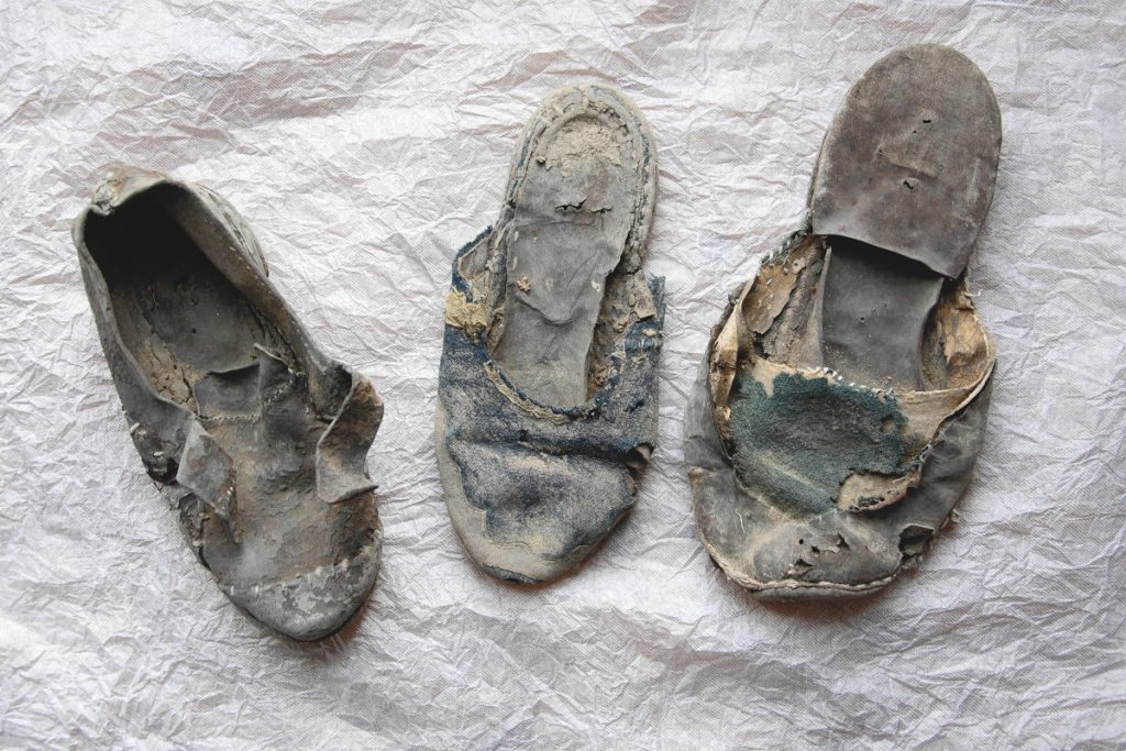 Drei alte braune kaputte Schuhe, wohl mehr als einhundert Jahre alt.