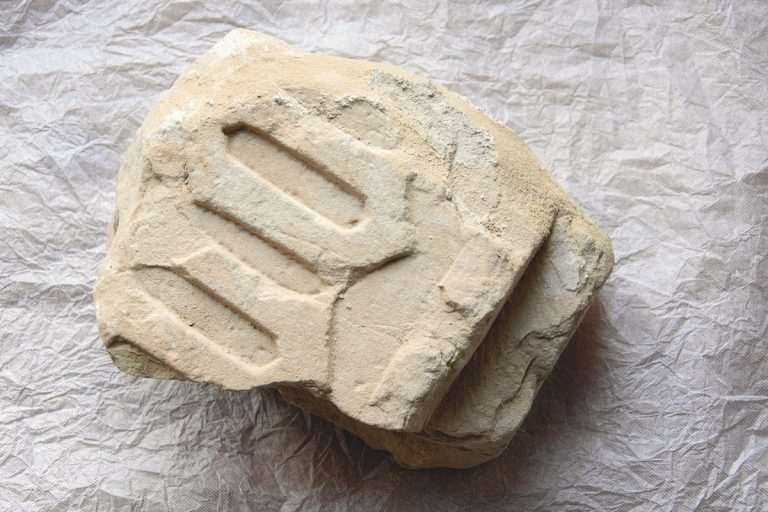 Ferienhaus Liebfrauenkirche. Fragment eines Sandstein-Gewendes mit gotischen Schriftzeichen.