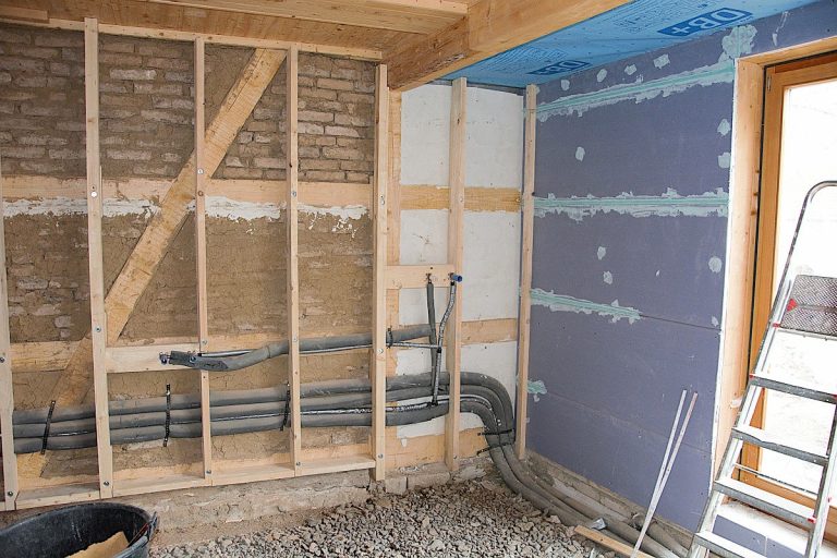 Ausmauerung Fachwerk mit alten Lehmsteinen und vorgesetzte Holzkonstruktion für Trockenbauwand.